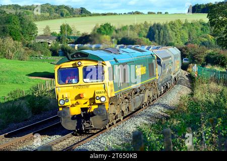 Freightliner Classe 66 potenze rotonde la curva a Crofton con un treno di pietra vuoto diretto a una delle cave di pietra del Somerset. Foto Stock