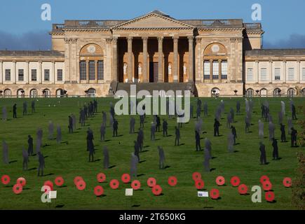 Silhouette e papaveri in metallo in PIEDI CON L'installazione artistica GIANTS Remembrance Day presso Stowe Gardens, Buckinghamshire, Inghilterra 11/2023 Foto Stock