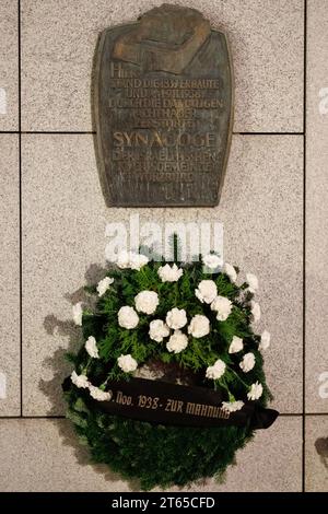 8 novembre 2023, Baviera, Würzburg: Una targa commemorativa è appesa sopra una corona nell'ex sito della sinagoga principale di Würzburg durante un evento commemorativo in occasione del 85° anniversario della notte del pogrom. Foto: Daniel Karmann/dpa Foto Stock