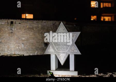 8 novembre 2023, Baviera, Würzburg: Una pietra commemorativa nell'ex sito della sinagoga principale di Würzburg viene illuminata durante un evento commemorativo in occasione del 85° anniversario della notte del pogrom. Foto: Daniel Karmann/dpa Foto Stock