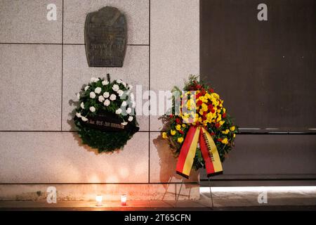 8 novembre 2023, Bavaria, Würzburg: Una targa commemorativa è appesa con ghirlande e candele nell'ex sito della sinagoga principale di Würzburg durante un evento commemorativo in occasione del 85° anniversario della notte del pogrom. Foto: Daniel Karmann/dpa Foto Stock