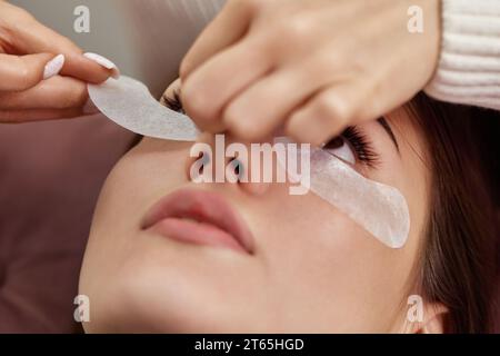 preparare il nastro adesivo in cotone sotto gli occhi prima della procedura di estensione delle ciglia Foto Stock