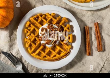 Colazione fatta in casa, waffle alla zucca con noci pecan e panna montata Foto Stock