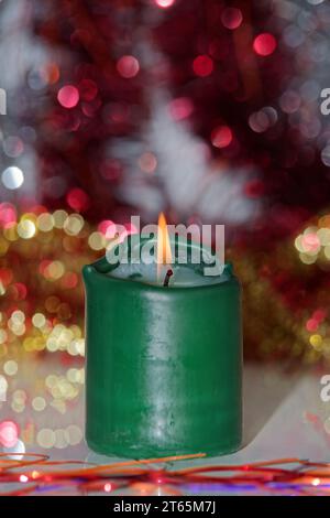 Una sola candela verde su sfondo sfocato. Concentrati sulla fiamma Foto Stock