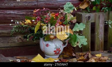 Bouquet di foglie autunnali colorate su una panchina di legno. Foto Stock