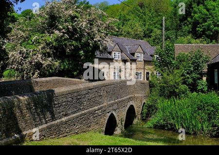 Ford: Vecchio ponte sul Brook con pub White Hart e fioritura nel villaggio Ford vicino a Castle Combe, Cotswolds, Wiltshire, Inghilterra, Regno Unito Foto Stock