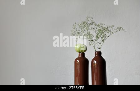 Composizione artistica minimalista. Frammenti di una vecchia casa di campagna interna - pareti intonacate illuminate, bottiglie in argilla smaltata Foto Stock