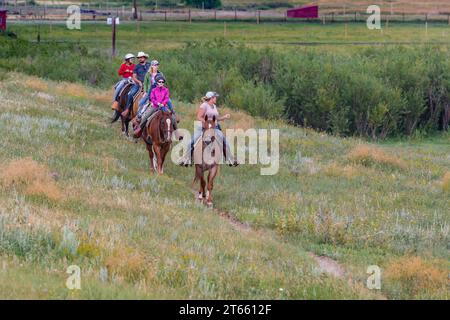 La tua famiglia è guidata da un'escursione a cavallo attraverso i campi del Terry Bison Ranch vicino a Cheyenne, Wyoming Foto Stock