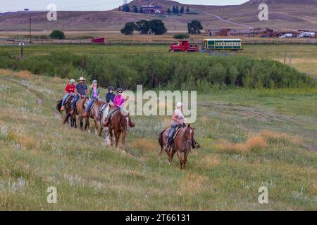 La tua famiglia è guidata da un'escursione a cavallo attraverso i campi del Terry Bison Ranch vicino a Cheyenne, Wyoming Foto Stock