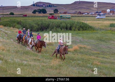 La tua famiglia è guidata da un'escursione a cavallo attraverso i campi del Terry Bison Ranch vicino a Cheyenne, Wyoming Foto Stock