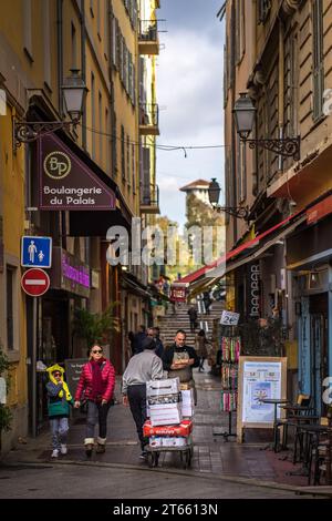 Nizza, Francia - 16 feb 2023: Vita di tutti i giorni nella città vecchia di Nizza, Francia, con la torre del Liceo Masséna sullo sfondo Foto Stock