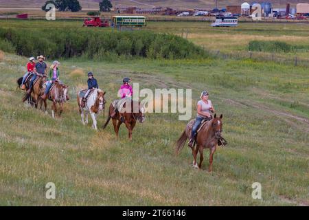 La tua famiglia è guidata da un'escursione a cavallo attraverso i campi del Terry Bison Ranch vicino a Cheyenne, Wyoming Foto Stock