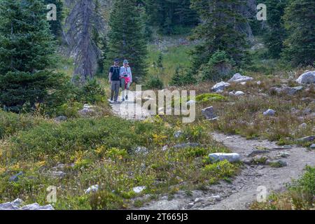 Giovani coppie che camminano su un sentiero vicino al lago Marie nella zona della catena montuosa di Medicine Bow National Forest, Wyoming Foto Stock