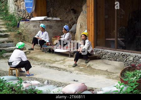 龙胜镇 (龙胜县) 中國 Longsheng, Longji Ping'an Zhuang, Cina; le donne cinesi sono sedute in una piccola bancarella; Chinesische Frauen sitzen an einem kleinen Stand Foto Stock