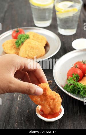 Nugget croccanti con salse piccanti e salse per le mani femminili Foto Stock