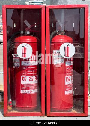 Budva, Montenegro - 08 agosto 2023: Due estintori rossi sono negli armadi dietro il vetro Foto Stock