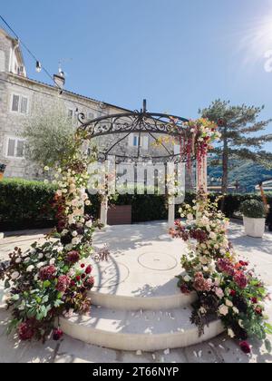 Arco nuziale Rotunda decorato con fiori in giardino Foto Stock