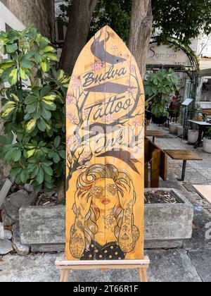 Budva, Montenegro - 08 agosto 2023: Elegante cartello di legno su una tavola da surf. Didascalia: Inchiostro per tatuaggi Budva Foto Stock