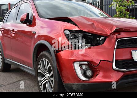 Un'auto che mostra danni ai pannelli e ai fari automatici per la riparazione in caso di incidente frontale. Foto Stock