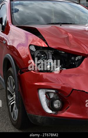 Un'auto che mostra danni ai pannelli e ai fari automatici per la riparazione in caso di incidente frontale. Foto Stock