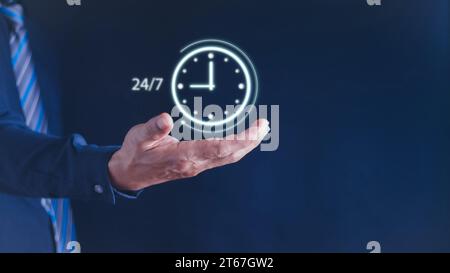 concetto di servizio continuo. uomo d'affari che tiene in mano virtuale 24-7 con orologio a portata di mano per contattare il servizio di assistenza in tutto il mondo senza interruzioni e a tempo pieno Foto Stock