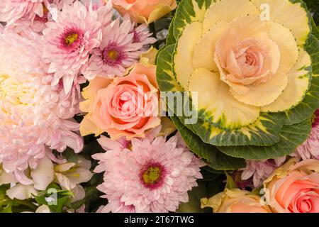 Bouquet di splendidi fiori con rose rosa, fiori di brassica, crisantemo e fiori di freesia come sfondo. Foto Stock