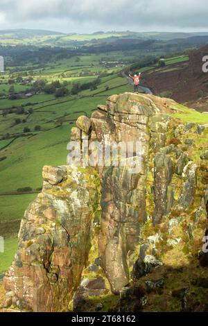 Un camminatore in piedi su uno sperone roccioso su Hen Cloud Hill, Staffordshire, Inghilterra Foto Stock