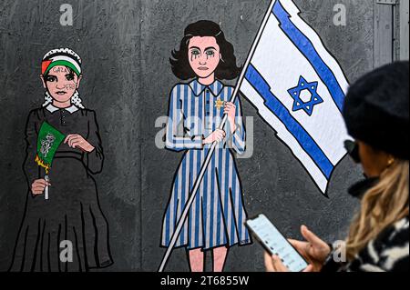 Milano, Italia. 9 novembre 2023. Un murales di strada intitolato "Innocence, Hate and Hope" dell'artista aleXsandro Palombo raffigurante una ragazza palestinese che brucia la bandiera di Hamas e Anna Frank che sventola una bandiera nazionale israeliana è stato visto nel centro di Milano, Italia il 9 novembre 2023 Credit: Piero Cruciatti/Alamy Live News Foto Stock