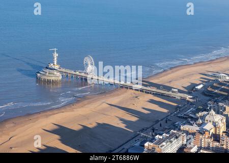 Molo Dutch Scheveningen con ruota panoramica sulla costa olandese con lunghe ombre Kurhaus sulla spiaggia Foto Stock