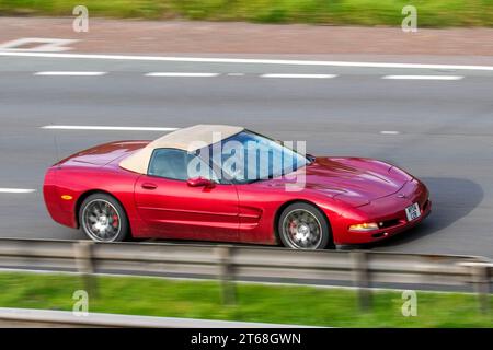 Guida a sinistra 2004 Red Chevrolet GMC Corvette, V8 Car Roadster benzina 5700 cc; in viaggio sull'autostrada M6 a Greater Manchester, Regno Unito Foto Stock