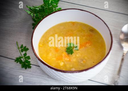 zuppa di piselli secchi in un piatto con erbe aromatiche, su un tavolo di legno. Foto Stock