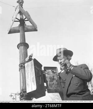 Taxi 1940S.. Un uomo vestito in modo ordinato con un vestito e un cappello si trova in un palo di un taxi a Stoccolma e chiama un taxi. In passato, era comune che un telefono collegato direttamente al centralino dei taxi fosse allestito presso le postazioni dei taxi, se non c'era un taxi lì, l'avete chiamato voi stessi. Svezia 1944. Kristoffersson rif. G73-2 Foto Stock