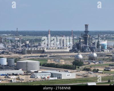 Una raffineria industriale di petrolio situata in un remoto paesaggio rurale, con diversi serbatoi di stoccaggio e impianti di lavorazione Foto Stock