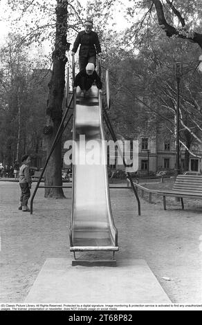 Parco giochi negli anni '1950 I bambini vengono visti scendere da uno scivolo in un parco a Stoccolma Svezia 1954. Kristoffersson rif. 1-38 Foto Stock