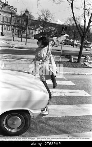 Negli anni '1960 Un momento in cui un uomo cammina su un attraversamento pedonale ma un'auto non l'ha notato e continua a guidare. L'uomo si allontana dalla macchina per evitare di essere colpito da essa. Svezia 1968. Kristoffersson rif. 3-57 Foto Stock