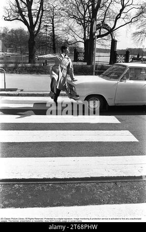 Negli anni '1960 Un momento in cui un uomo cammina su un attraversamento pedonale ma un'auto non l'ha notato e continua a guidare. L'uomo si allontana dalla macchina per evitare di essere colpito da essa. Svezia 1968. Kristoffersson rif. 3-57 Foto Stock