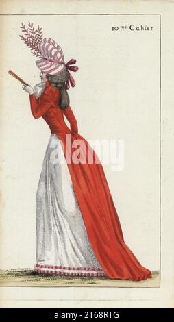 Donna alla moda con outfit casual, in negligenza. Chapeau un soufflet in taffetas a righe rosa, arrosto scarlatto, fichu garza, petticoat di lino bianco con nastro rosa. Incisione su copperplate a mano di Jean-Antoine le Brun o Lebrun-Tossas Journal de la Mode et du Gout, precedentemente Cabinet des Modes, Chez Buisson, Parigi, e Joseph le Boffe, Londra, 10me Cahier, 25 maggio 1790. Foto Stock