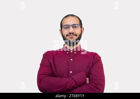 Uomo barbuto che indossa una camicia Borgogna con posa sicura e sospira sul viso su sfondo bianco e isolato Foto Stock