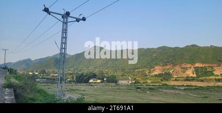 Una vista pittoresca di un paesaggio collinare punteggiato da linee elettriche Foto Stock