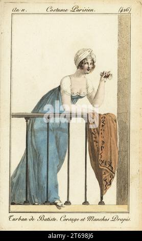 Donna sul balcone del teatro in turbante cambric. Tiene un vetro d'opera, indossa un vestito con corpetto smerlato e maniche, e poggia il suo scialle sulla balaustra. Turban de Batiste. Corsage et Manches Drapés. Incisione in copperplate a mano da Pierre de la Mesangeres Journal des Dames et des Modes, Magazine of Women and Fashion, Paris, An 11, 1803. Illustrazioni di Carle Vernet, Jean-Francois Bosio, Dominique Bosio e Philibert Louis Debucourt, incise da Pierre-Charles Baquoy. Foto Stock