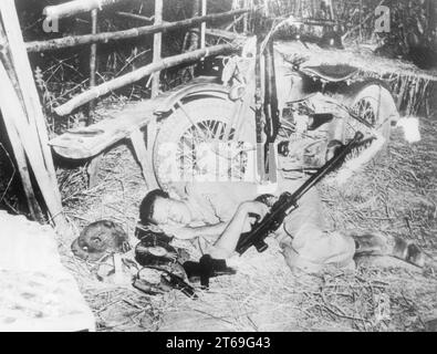 Un soldato americano dorme esausto accanto alla sua moto durante i combattimenti nella penisola di Bataan nelle Filippine. [traduzione automatica] Foto Stock