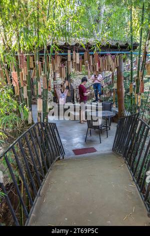 Le targhe con i messaggi dei clienti più esigenti sono appese all'ingresso del ristorante e caffetteria Akha Cottage a Chiang Rai, Thailandia Foto Stock