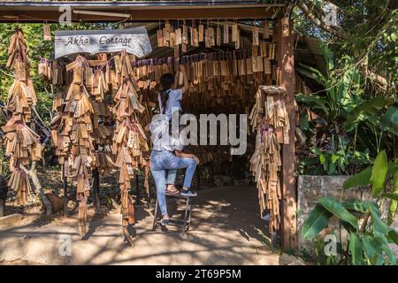 Le donne thailandesi appendono la loro targa di messaggio personale vicino all'ingresso del ristorante e caffetteria Akha Cottage a Chiang Rai, Thailandia Foto Stock