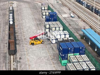 CHONGQING, CINA - 9 NOVEMBRE 2023 - Un treno scarica container presso il sito di una ferrovia speciale per lo sviluppo economico e tecnologico di Changshou Foto Stock