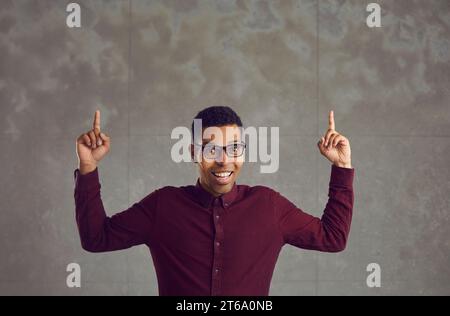 Uomo afroamericano con una faccia divertente che tiene le mani puntate verso l'alto Foto Stock