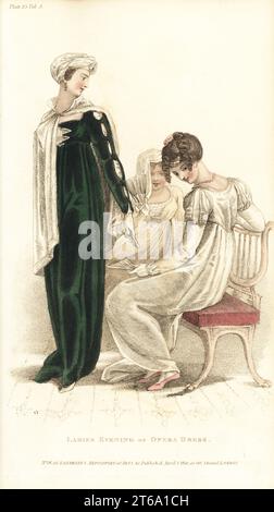 Reggenza donne all'opera in abiti da sera. Donna (in piedi) in accappatoio a la russe di velluto verde, turbante Mirza, collana di diamante. Donna (seduta) in slip bianco satinato a l'antique, pizzo gotico, stomacher con lacci, ciabatte rosa satinato. Donna (posteriore) in grecia di aurora gause su satin bianco. Targa 25, 1 aprile 1810. Incisione in copperplate a mano di Thomas Uwins dal Rudolph Ackermann's Repository of Arts di Londra. Foto Stock