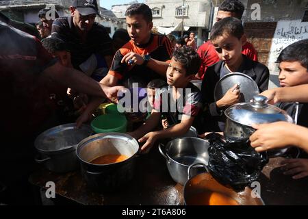 Gaza. 9 novembre 2023. I palestinesi fanno la coda per ricevere cibo in una cucina di beneficenza improvvisata nella città meridionale di Rafah, 9 novembre 2023. Mercoledì, il ministero della salute con sede a Gaza ha detto che gli scioperi israeliani su Gaza hanno ucciso almeno 10.569 palestinesi, tra cui 4.324 bambini. Nel frattempo, quasi 1,5 milioni di palestinesi sono sfollati all'interno dell'enclave assediata. Crediti: Khaled Omar/Xinhua/Alamy Live News Foto Stock