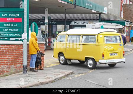 Morrisons Daily Shop e stazione di rifornimento carburante crossover e negozio di cibo da asporto VW Volkswagen camper gialli, camper, camper, camper e cani che aspettano di attraversare Cromer UK Foto Stock