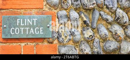 L'uso di ciottoli di selce come materiale da costruzione e come rivestimento per rivestimenti murali è illustrato qui in questo cartello del cottage a Suffolk East Anglia, Inghilterra, Regno Unito Foto Stock