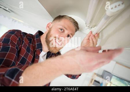 elettricista certificato che installa la lampadina Foto Stock